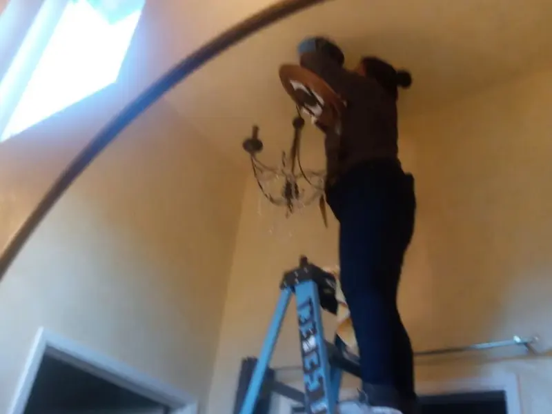 Electrician installing a chandelier in a Nashville residence